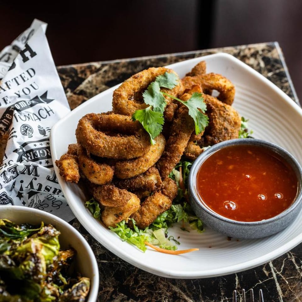 Crispy fried calamari rings with fresh cilantro, served with a side of sweet chili dipping sauce.